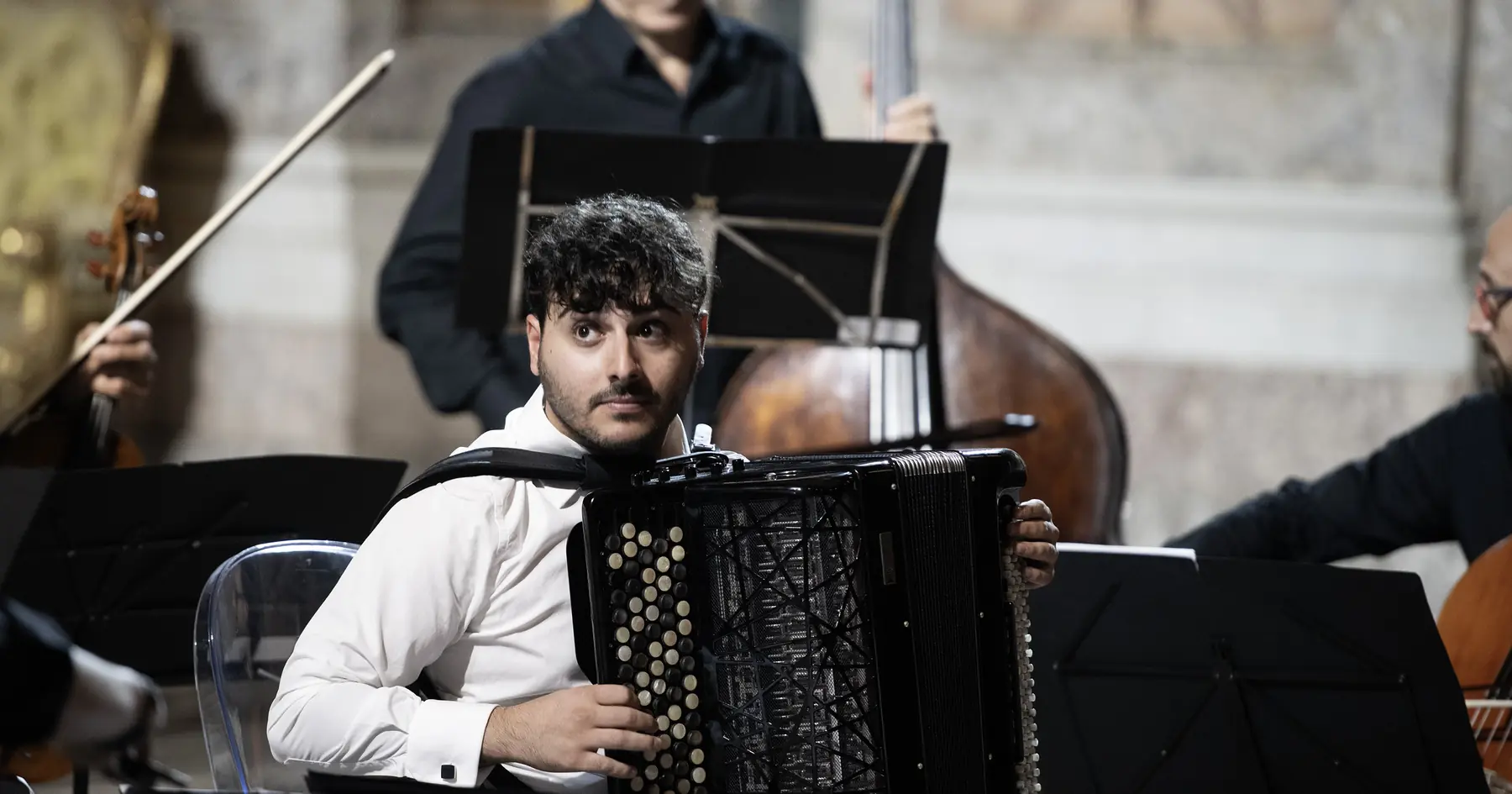 Luigi Gordano on stage with double bass and strings behind him
