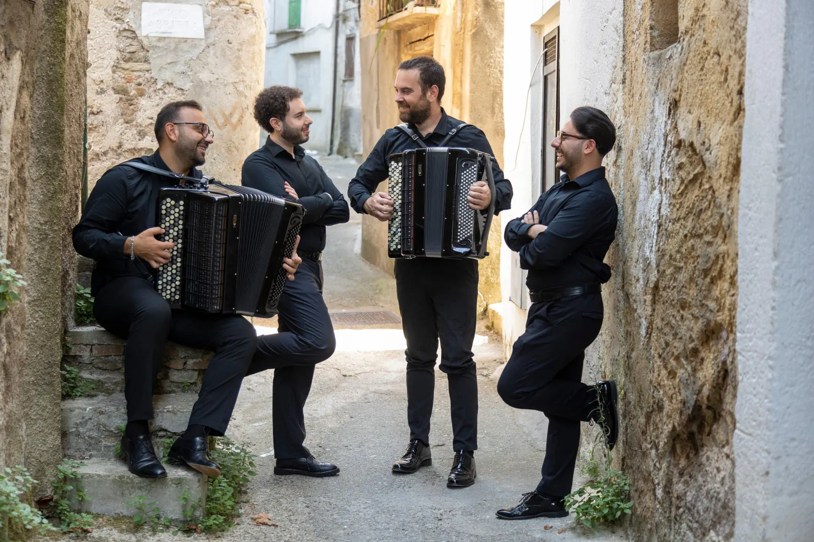 Orpheus’s Accordion Quartet: Luigi Gordano, Giuseppe Bozzo, Fausto Credidio and Eugenio De Rose with their accordions in a stone alley